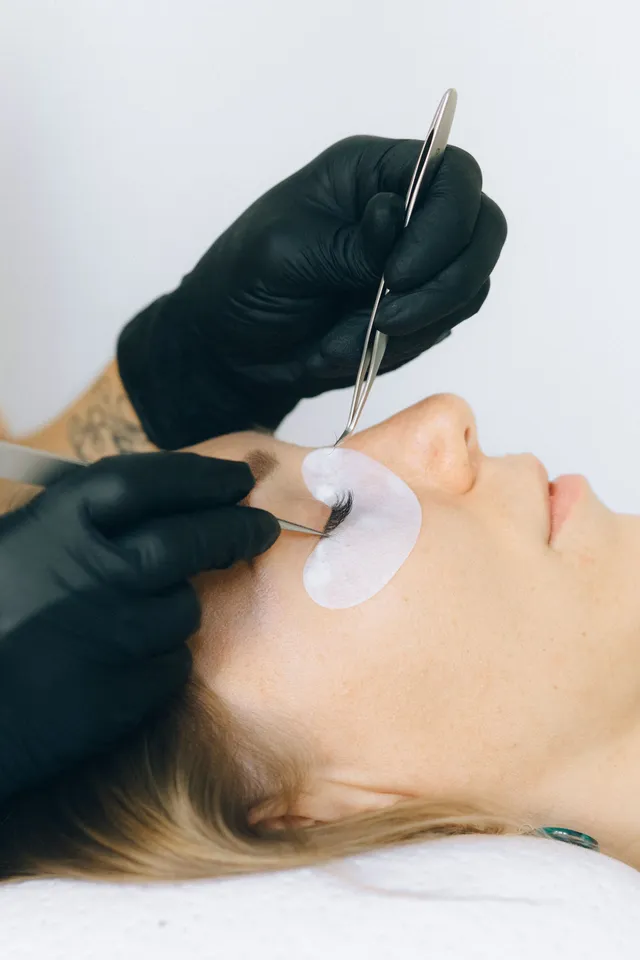 Lash artist applying individual extensions with tweezers