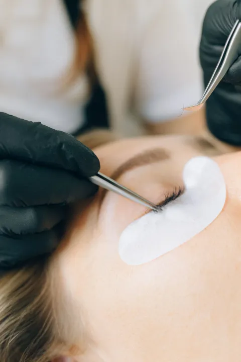 Lash technician carefully applying extensions
